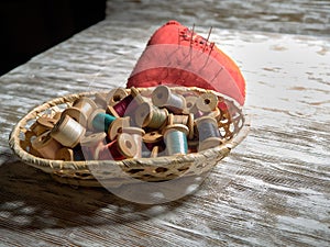 Bright thread on wooden spools, thimbles and needles