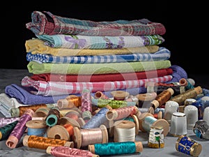 Bright thread on wooden spools, thimbles and needles