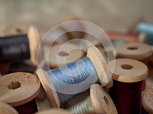 Bright thread on wooden spools, thimbles and needles