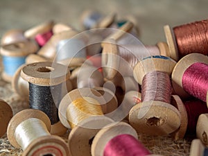 Bright thread on wooden spools, thimbles and needles