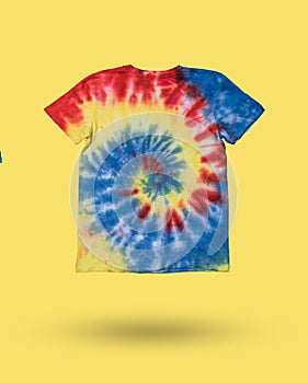 A bright tie dye T-shirt on a bright yellow background