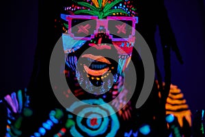 Bright UV body art, fluorescent paint, dancer man in sunglasses