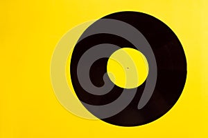 Bright vinyl record of modern fashionable music close-up on a yellow background. summer music concept with copy space