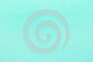 Bright water droplets on soft light mint or aquamarine background as fresh pattern of tiny drops as spray or dew, texture.