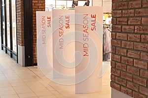 Bright white advertising banner at the entrance to the mall. Offer of seasonal discounts in the store