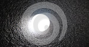 Bright white light at end of gray pipe closeup