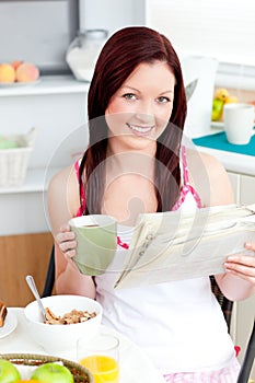 Bright woman eating cereals and reading newspaper