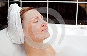 Bright woman relaxing in a bubble bath