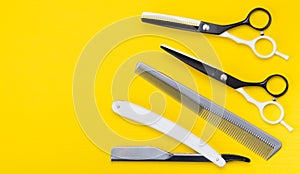 Bright yellow background. a set of items for cutting hair, scissors, and combs, and dangerous