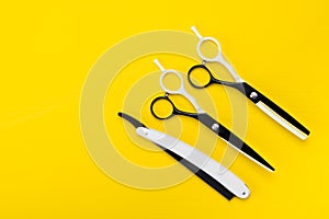 bright yellow background, there are scissors and a comb, to shorten the hair and create a hairstyle.