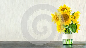 Bright yellow big sunflowers in glass vase on dark table on light texture background. Mockup banner with sunflower bouquet with c