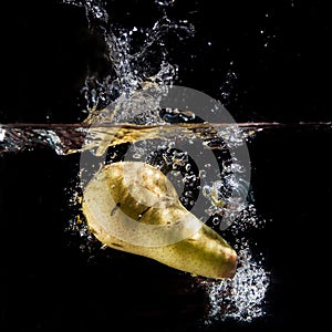 Bright yellow pear in clear water