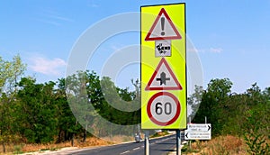 Bright yellow and red metal traffic signs and blurred road traffic