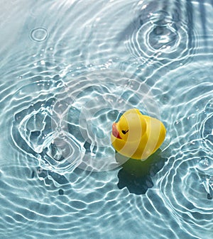 Bright yellow rubber duck floats in blue water pool.