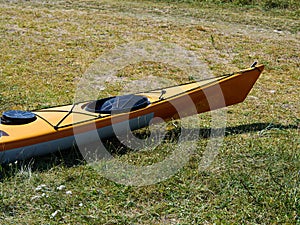 Bright yellow sea kayak on the beach