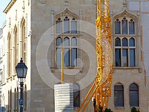 Bright yellow steel truss crane structure and gray concrete counterweight