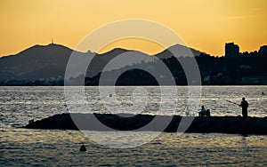 Bright yellow sunset on beach with sunset in Juan les Pins, Cote d`Azur, France