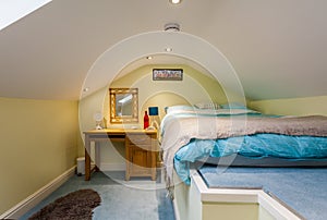 Bright yellow and white furnished attic bedroom