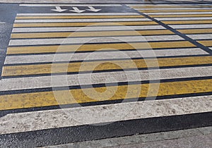 Bright yellow and white stripes of zebra crossing, pedestrian crosswalk