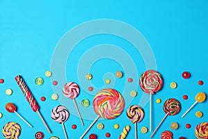 Bright yummy candies and space for text on color background, flat lay