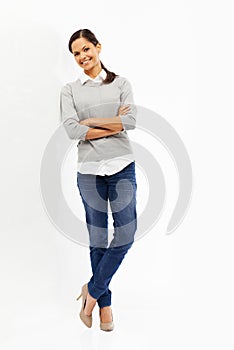 She brightens anywhere with her smile. Studio portrait of an attractive young woman standing with her arms crossed