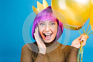 Brightful positive emotions at celebrating new year, birthday party of funny joyful young woman with cut purple hair on