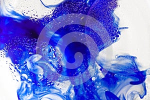 Brightl blue paint flows inside water with bubbles form of the butterfly