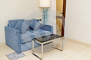 Brightly and classic suite, Hotel room with modern interior, gray couch, sofa with pillows, little table. holiday relaxation