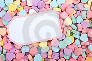 Brightly colored candy hearts, white card with pink border