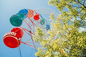 Brightly colored Ferris wheel against the blue sky