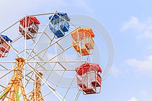 Brightly colored Ferris wheel on the blue sky
