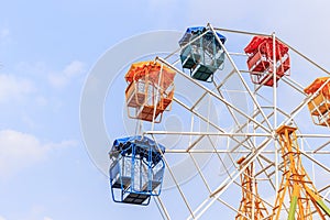 Brightly colored Ferris wheel on the blue sky