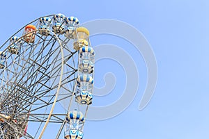 Brightly colored Ferris wheel on the blue sky