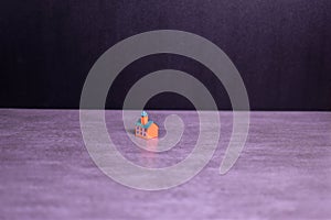 Brightly colored model building on dark background emphasizes architectural detail, isolation, and visual contrast in a