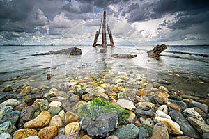 Brightly colored rocks and green underwater seaweed seen through the crystal clear waters of harbor port at lake