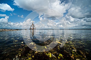 Brightly colored rocks and green underwater seaweed seen through the crystal clear waters of harbor port at lake