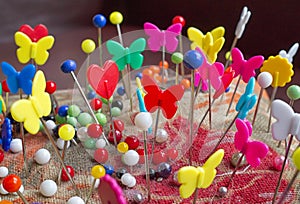 Brightly coloured dressmaking pins in a fabric pin cushion. photo