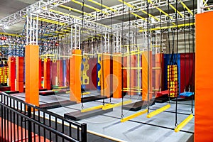 Brightly coloured interior ninja warrior parkour gym obstacle course with aerial netting