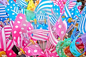 Brightly coloured plastic seaside windmills. Background.