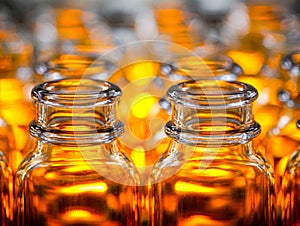 Brightly illuminated amber glass bottles in a visually striking pattern