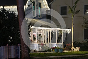 Brightly illuminated christmas decorations on front yard porch of florida family home. Outside decor for winter holidays