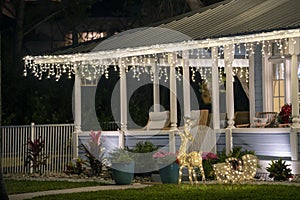 Brightly illuminated christmas decorations on front yard porch of florida family home. Outside decor for winter holidays