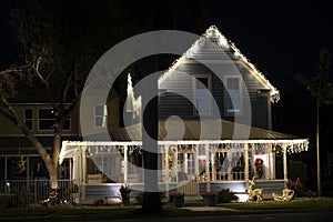 Brightly illuminated christmas decorations on front yard porch of florida family home. Outside decor for winter holidays
