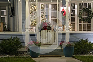 Brightly illuminated Christmas decorations on front yard porch of Florida family home. Outside decor for winter holidays