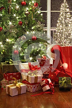 Brightly lit christmas tree with lots of gifts photo