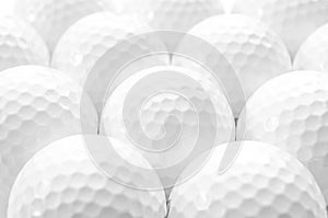 Brightly lit image of several golf balls creating a full frame pattern isolated on white background