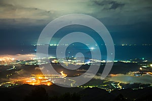 Brightly lit Taipei city night scene with dynamic clouds in the sky.