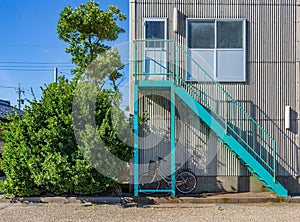 Brightly painted metal staircase with bicycle, Mikawa, Japan