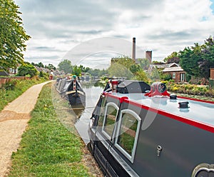 Brightly Painted moored houseboats on the Leeds-Liverpool canal on a bright summer day with beautiful shimmering water