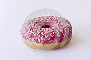 Brightly pink donut on a white background